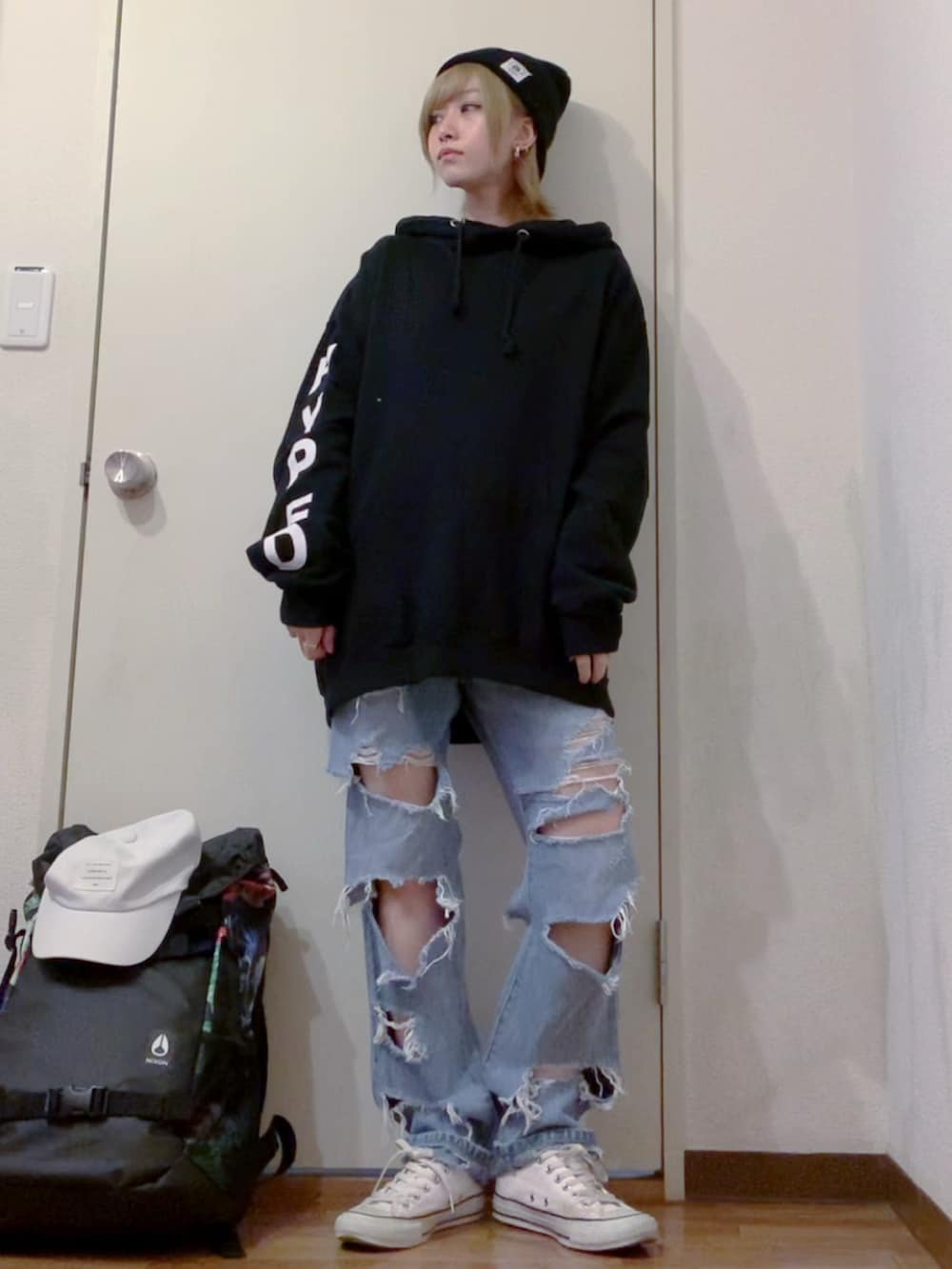 ブラック系のパーカー、ブルー系のデニムパンツ、ホワイト系のスニーカーを着用したレディースの冬コーディネートの3枚目の写真