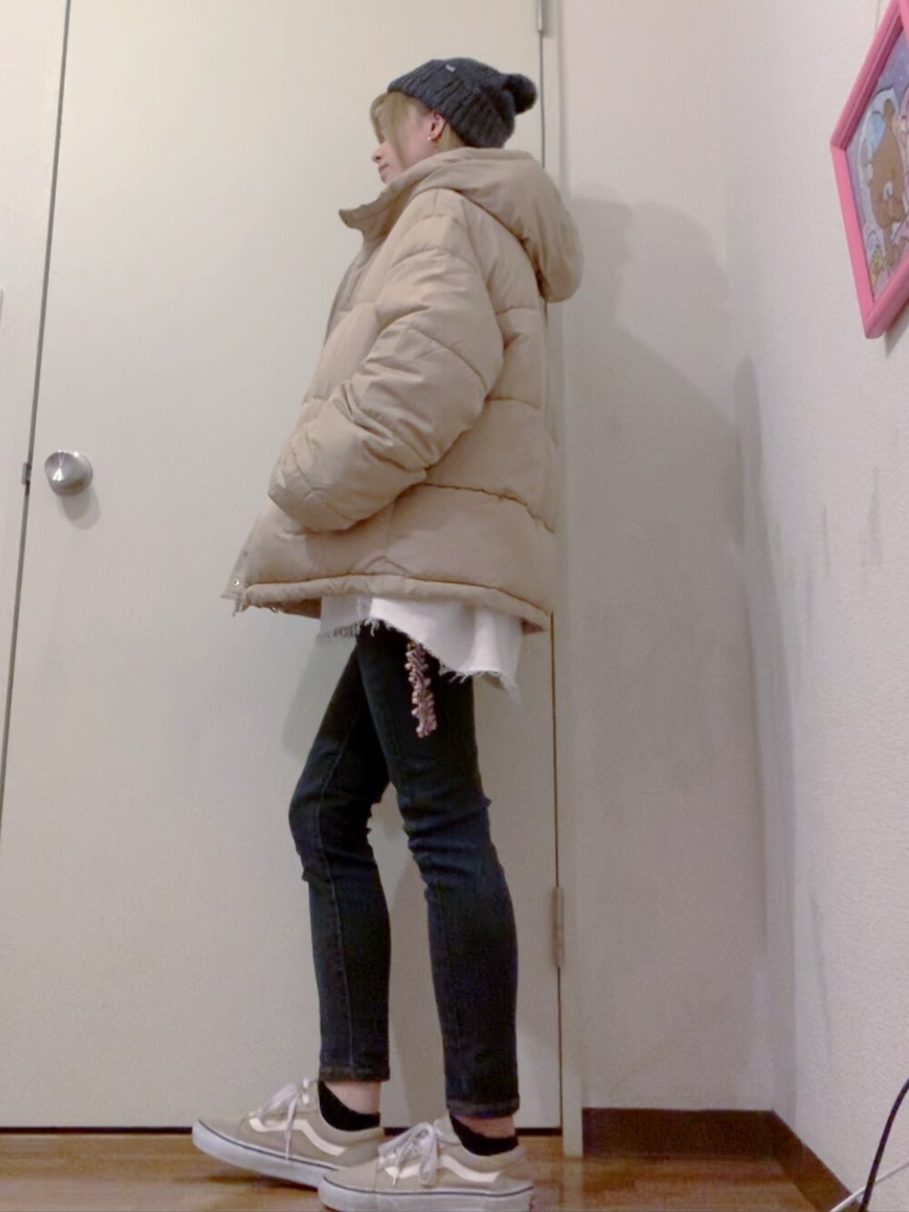 ホワイト系のスウェット、ブラック系のデニムパンツ、ベージュ系のダウンジャケット/コートを着用したレディースの冬コーディネートの4枚目の写真