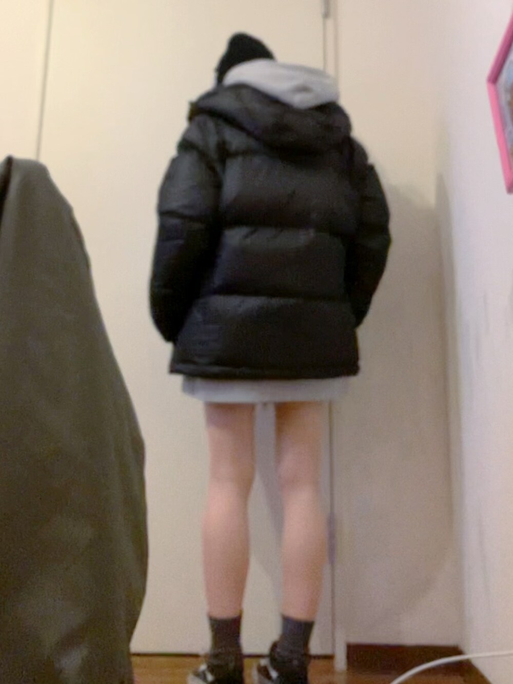 グレー系のパーカー、ブラック系のダウンジャケット/コート、ブラック系のニット/セーターを着用したレディースの冬コーディネートの5枚目の写真