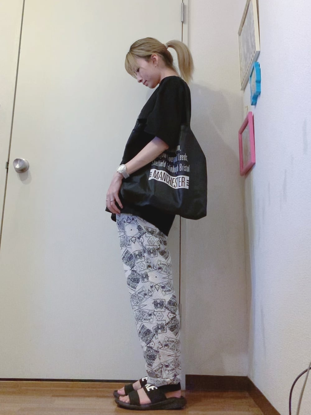 ブラック系のTシャツ/カットソー、ホワイト系のその他パンツ、ブラック系のサンダルを着用したレディースの夏コーディネートの2枚目の写真