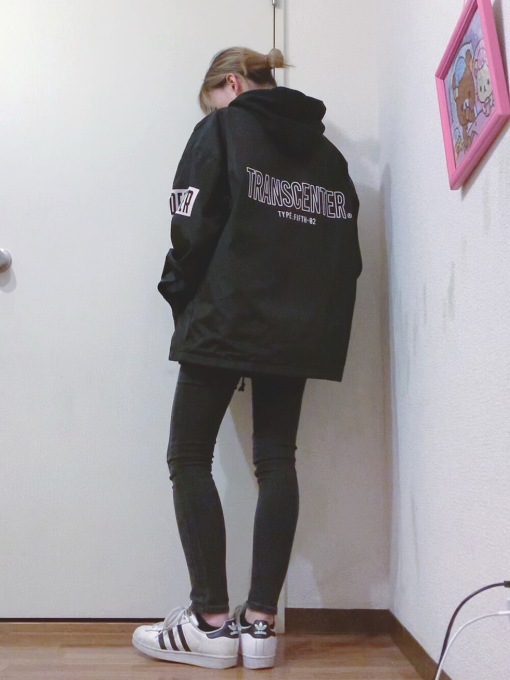 ブラック系のパーカー、ブラック系のデニムパンツ、ブラック系のナイロンジャケットを着用したレディースの春コーディネートの3枚目の写真