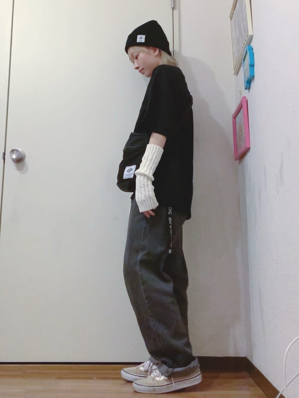 ブラック系のTシャツ/カットソー、ブラック系のデニムパンツ、ベージュ系のスニーカーを着用したレディースの秋コーディネートの4枚目の写真