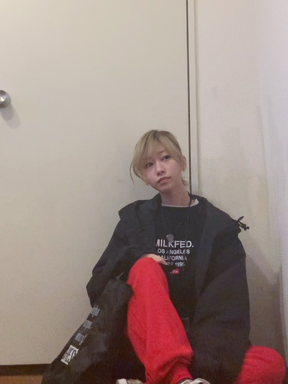 ブラック系のナイロンジャケット、ブラック系のスウェット、レッド系のスウェットパンツを着用したレディースの春コーディネートの3枚目の写真