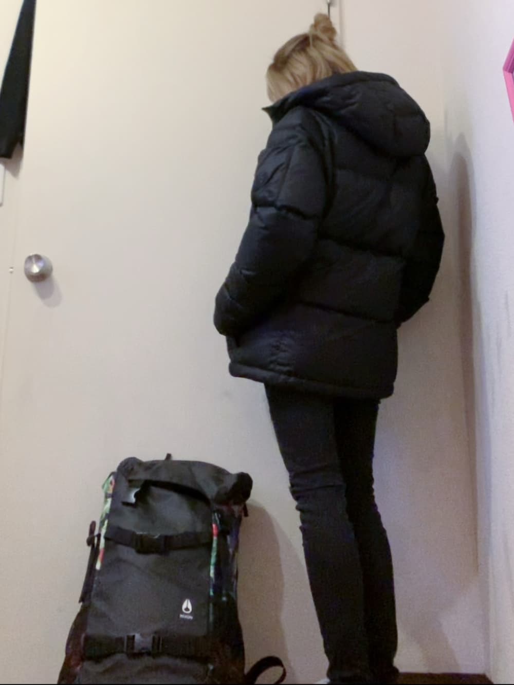 ブラック系のニット/セーター、ブラック系のダウンジャケット/コート、ブラック系のスニーカーを着用したレディースの春コーディネートの3枚目の写真