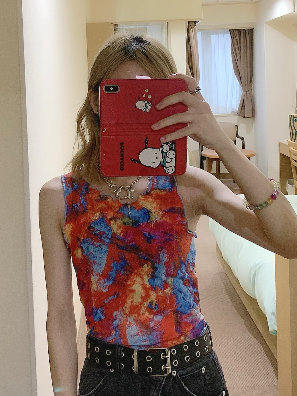 レッド系のタンクトップ、ブラック系のデニムパンツ、ブラック系のサンダルを着用したレディースの夏コーディネートの4枚目の写真