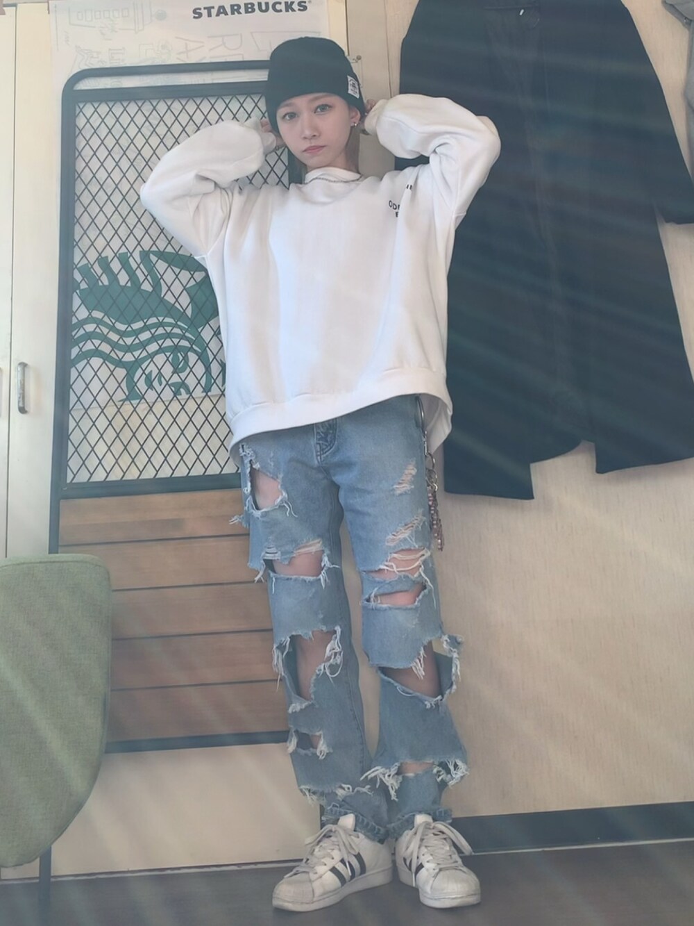 グレー系のチェスターコート、ホワイト系のスウェット、ブルー系のデニムパンツを着用したレディースの冬コーディネートの2枚目の写真