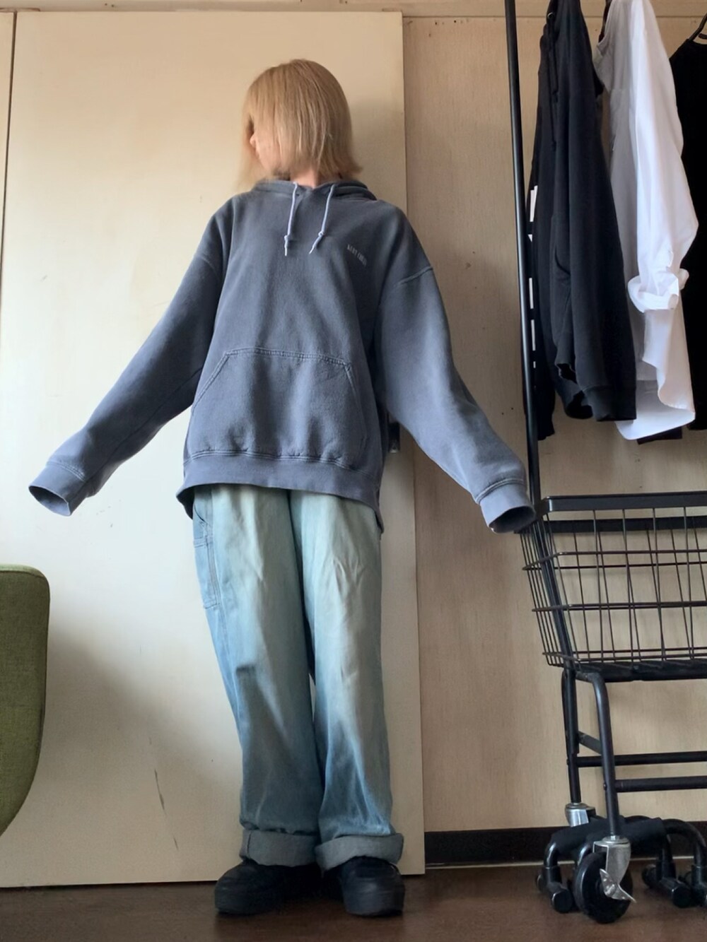 グレー系のパーカー、ブルー系のデニムパンツ、ブラック系のスニーカーを着用したレディースの秋コーディネートの3枚目の写真