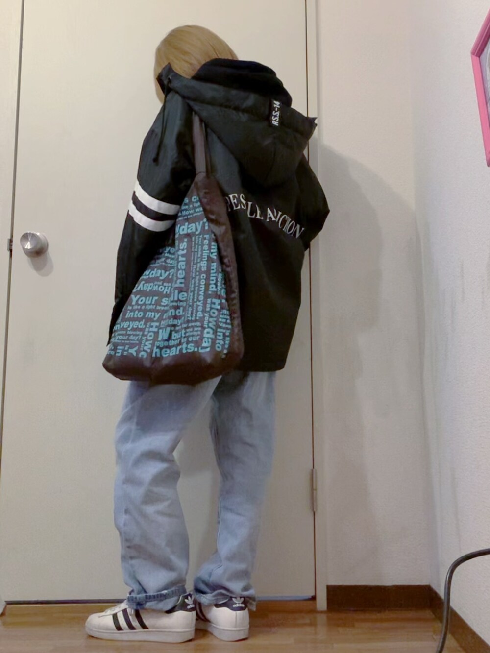 ブラック系のパーカー、ブルー系のデニムパンツ、ブラック系のナイロンジャケットを着用したレディースの冬コーディネートの2枚目の写真