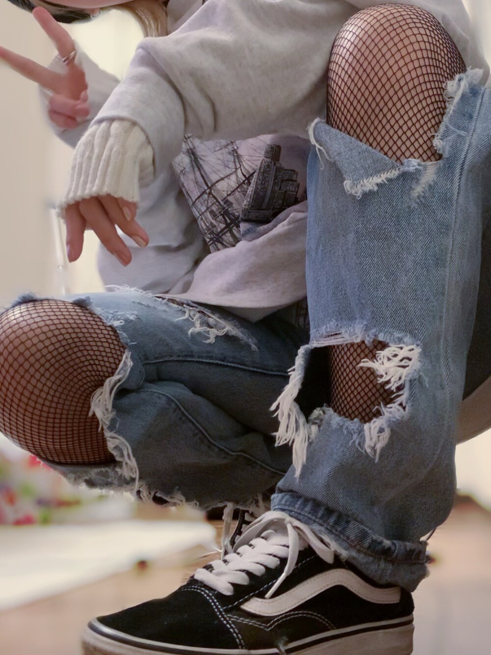 グレー系のスウェット、ブルー系のデニムパンツ、ブラック系のスニーカーを着用したレディースの秋コーディネートの4枚目の写真