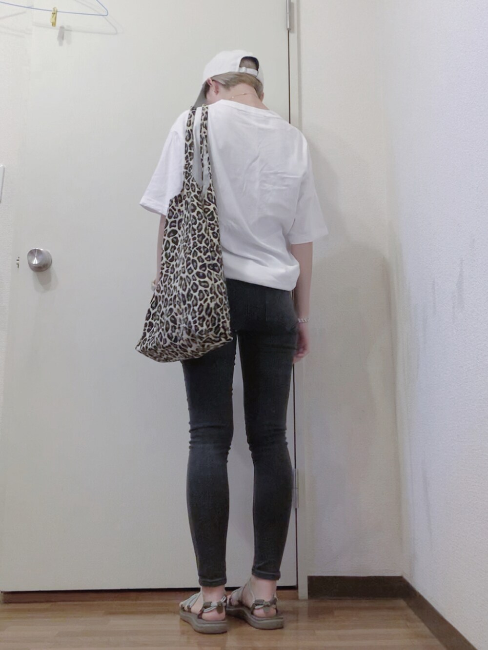 ホワイト系のTシャツ/カットソー、ブラック系のデニムパンツ、グリーン系のサンダルを着用したレディースの夏コーディネートの2枚目の写真