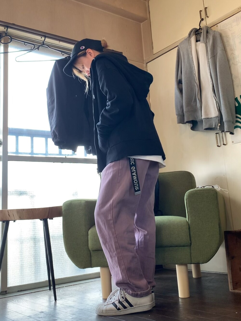 ホワイト系のTシャツ/カットソー、ブラック系のパーカー、パープル系のデニムパンツを着用したレディースの春コーディネートの2枚目の写真