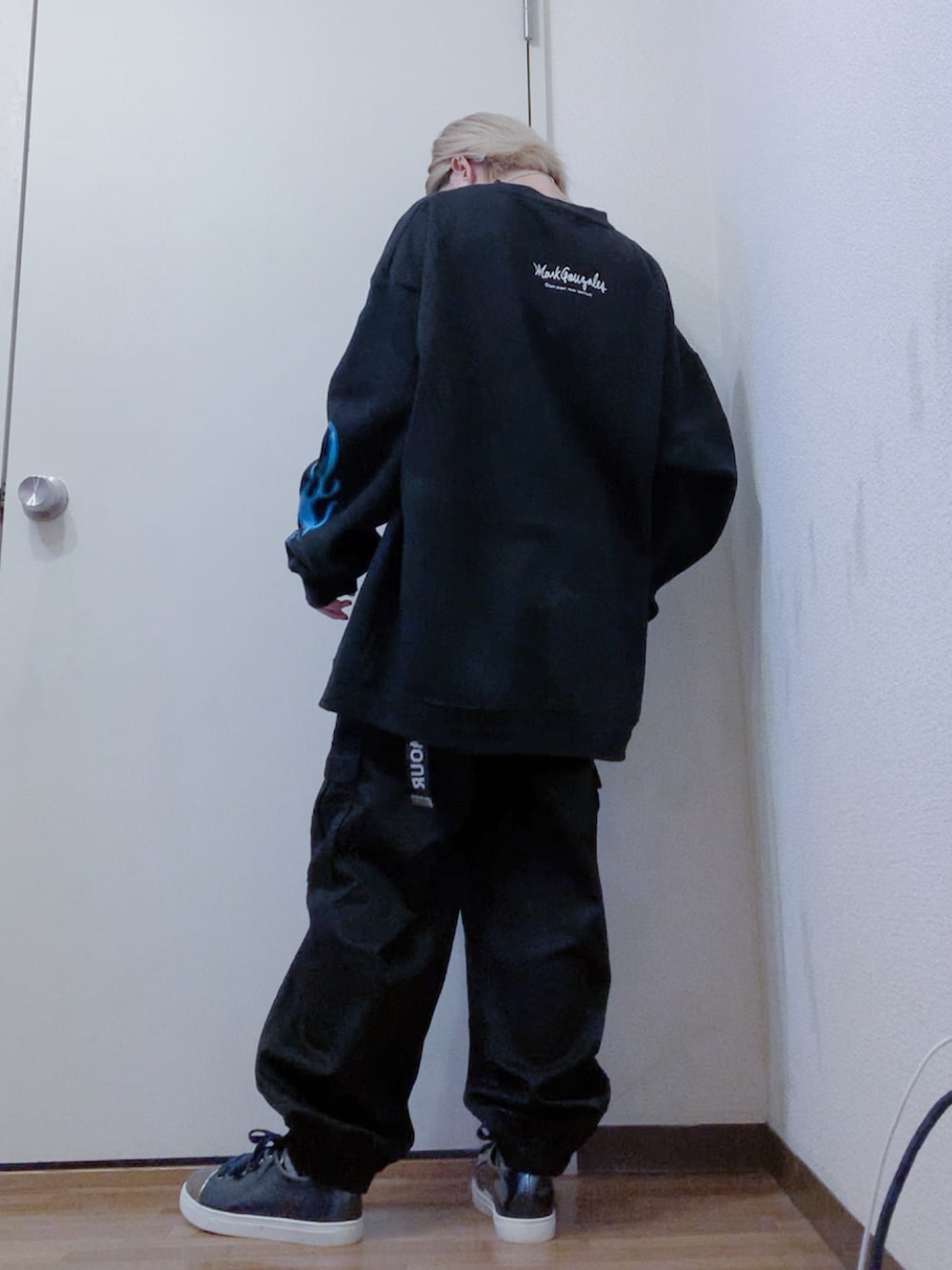 ブラック系のカーゴパンツ、ブルー系のスニーカー、ブラック系のスウェットを着用したレディースの春コーディネートの3枚目の写真