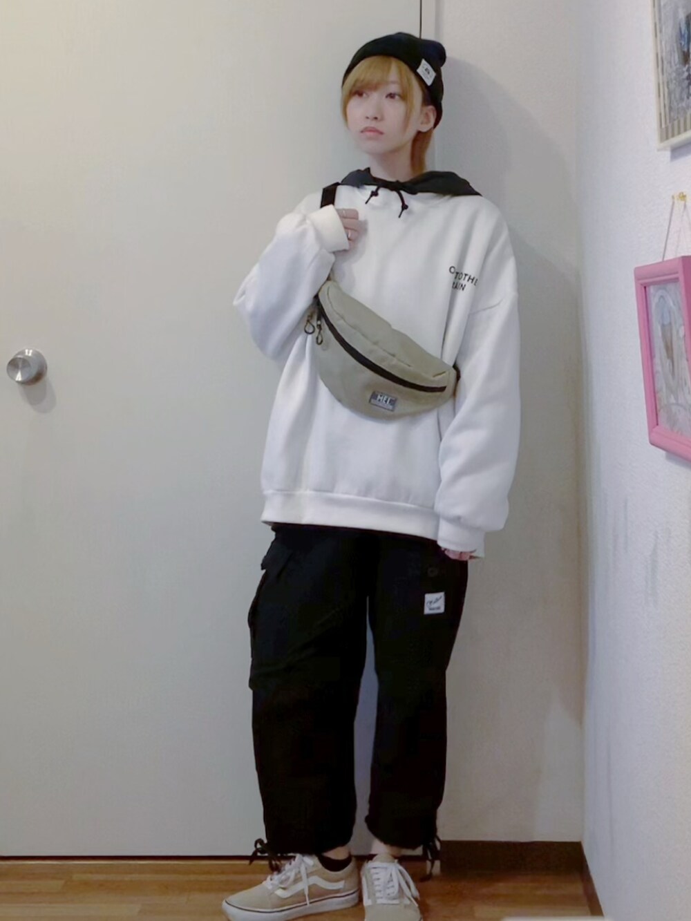 ホワイト系のスウェット、ブラック系のパーカー、ブラック系のカーゴパンツを着用したレディースの秋コーディネートの3枚目の写真