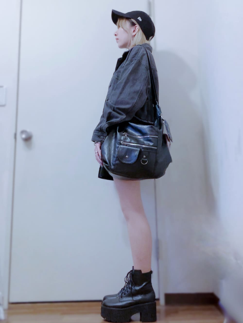 ブラック系のニット/セーター、ブラック系のデニムジャケット、ブラック系のスカートを着用したレディースの秋コーディネートの2枚目の写真