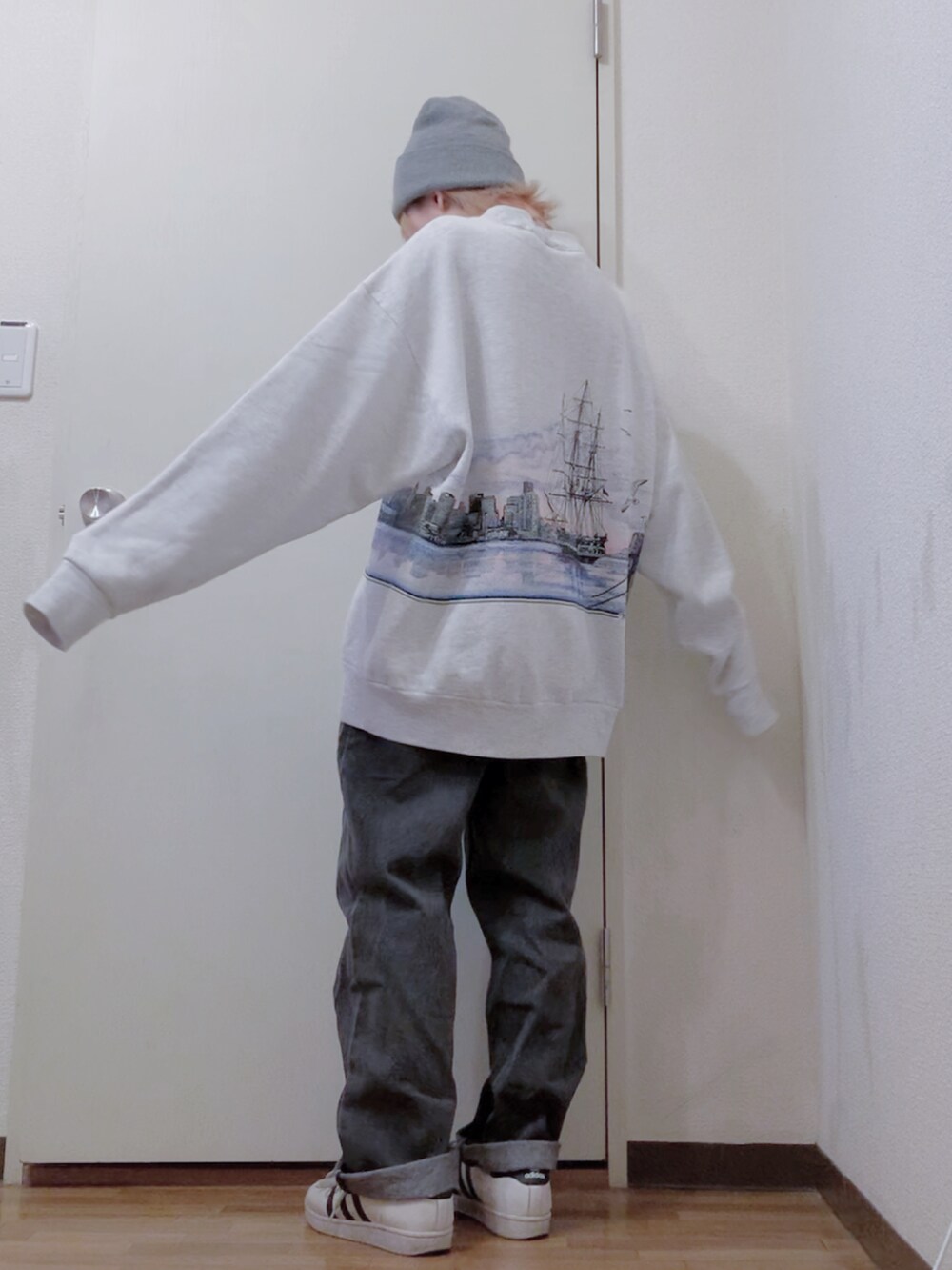 グレー系のスウェット、ブラック系のダウンジャケット/コート、ブラック系のデニムパンツを着用したレディースの冬コーディネートの3枚目の写真