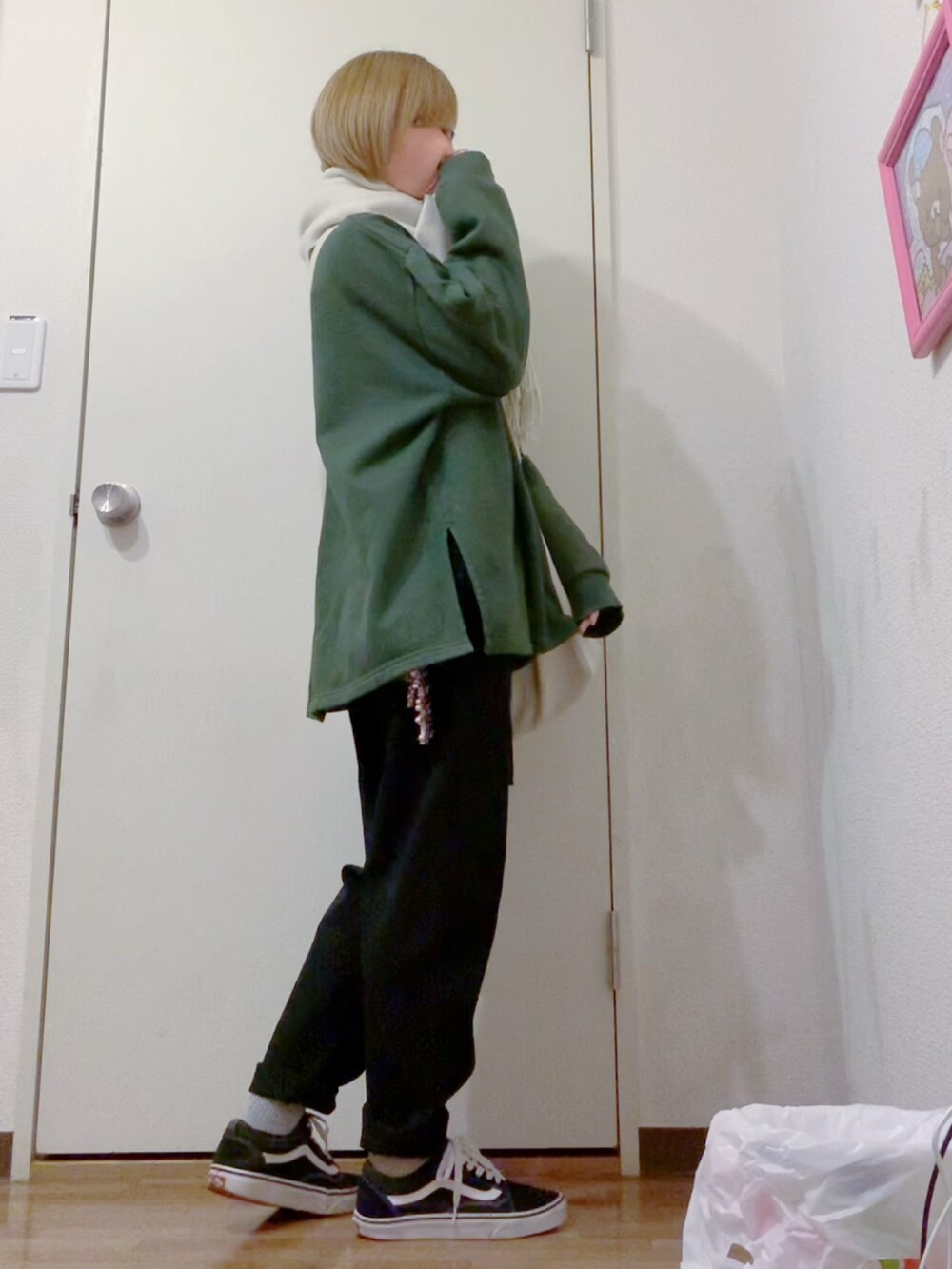 グリーン系のスウェット、ブラック系のデニムパンツ、ブラック系のスニーカーを着用したレディースの冬コーディネートの4枚目の写真