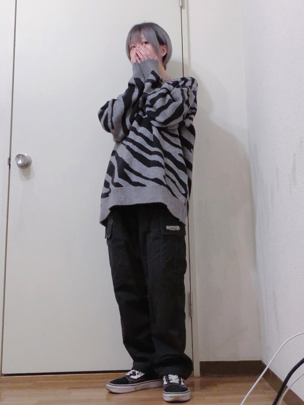 グレー系のニット/セーター、ブラック系のカーゴパンツ、ブラック系のスニーカーを着用したレディースの冬コーディネートの2枚目の写真