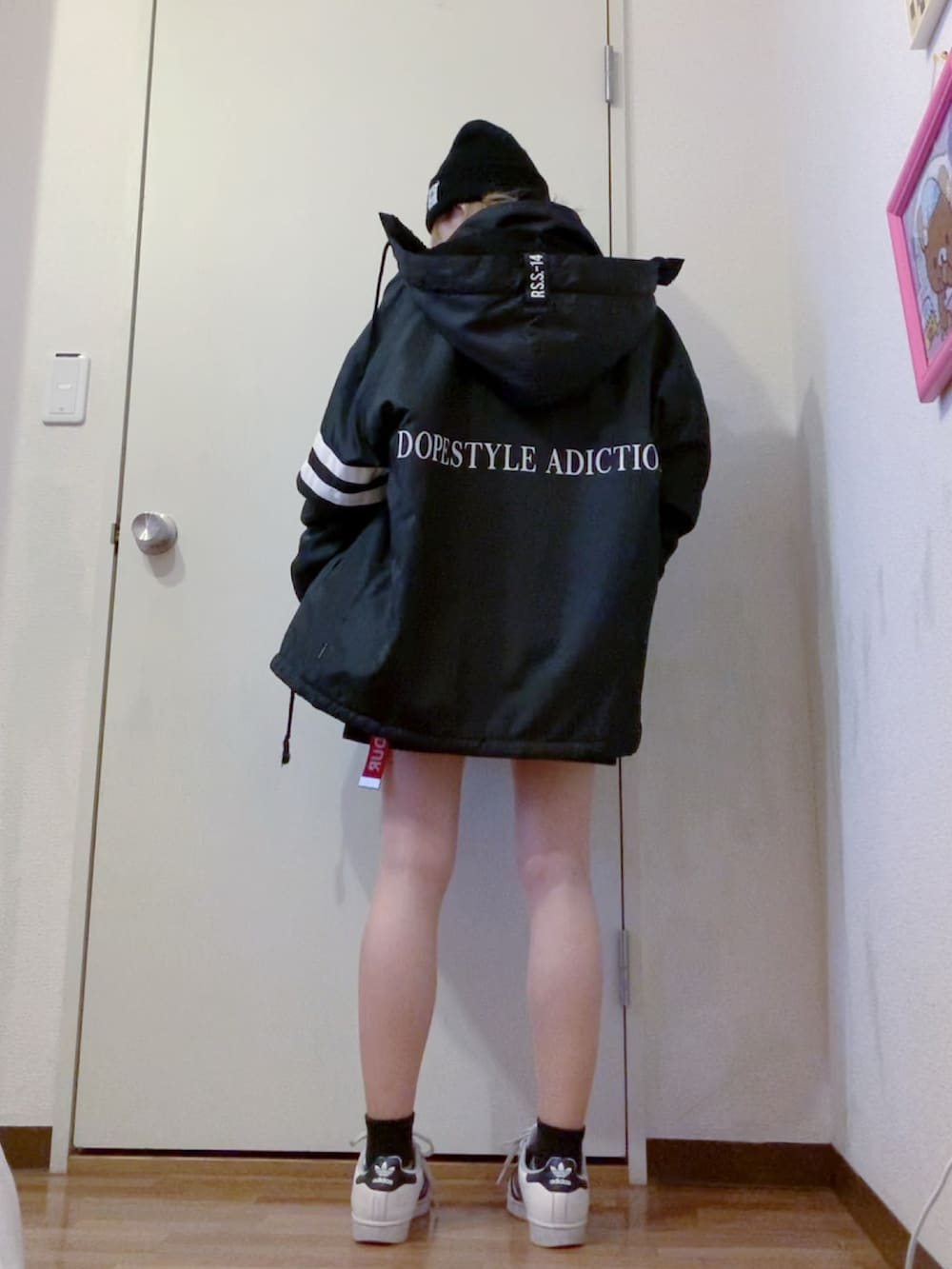 ブラック系のスウェット、ブラック系のスカート、ブラック系のナイロンジャケットを着用したレディースの春コーディネートの3枚目の写真