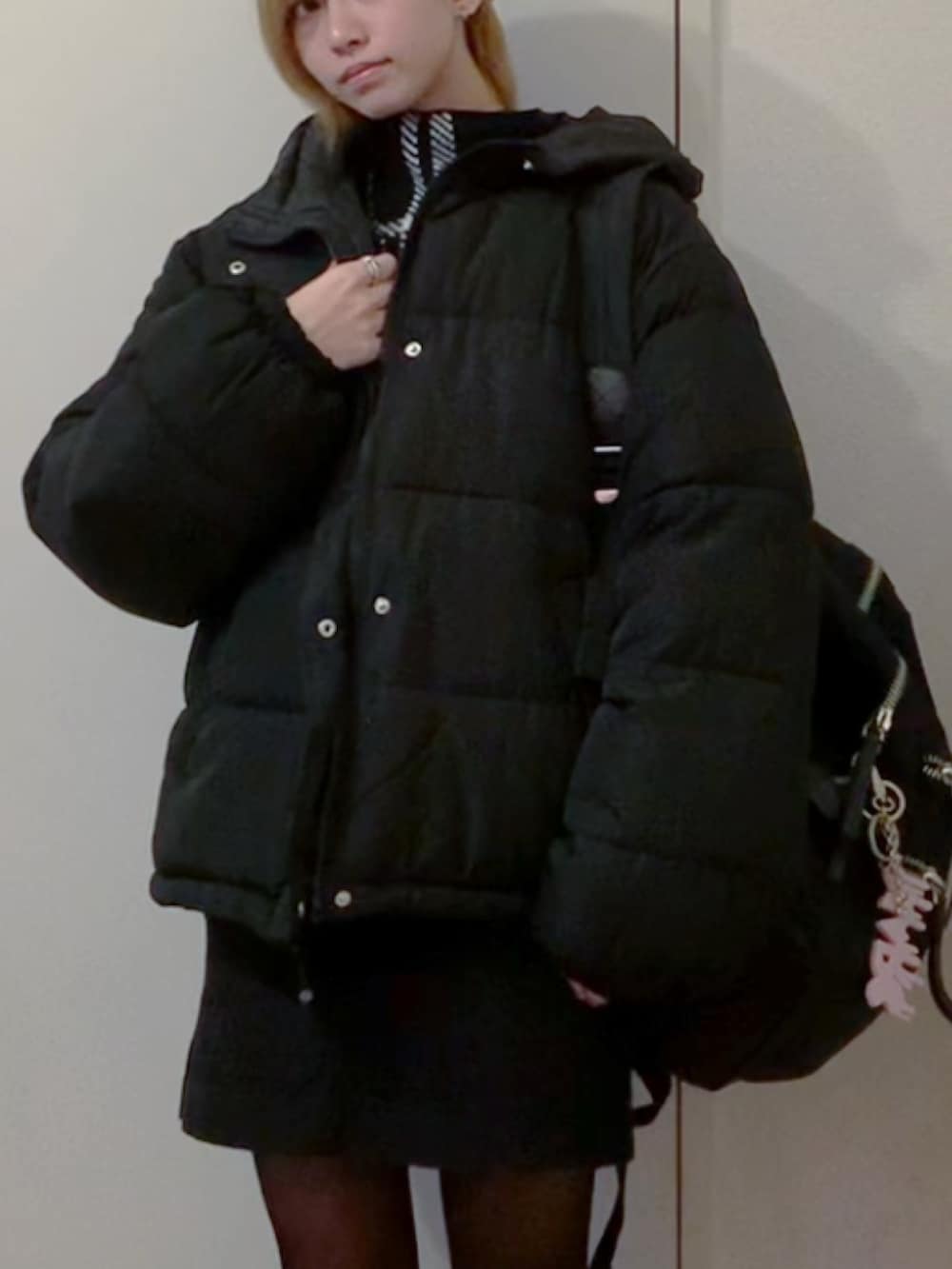 ブラック系のニット/セーター、ブラック系のスカート、ブラック系のスニーカーを着用したレディースの秋コーディネートの4枚目の写真