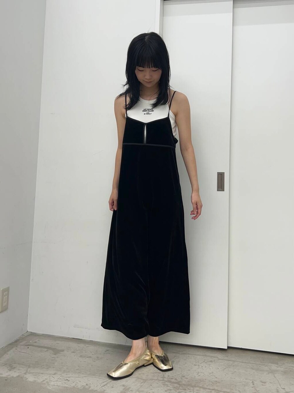 ホワイト系のタンクトップ、ブラック系のワンピースを着用したレディースの夏コーディネートの2枚目の写真