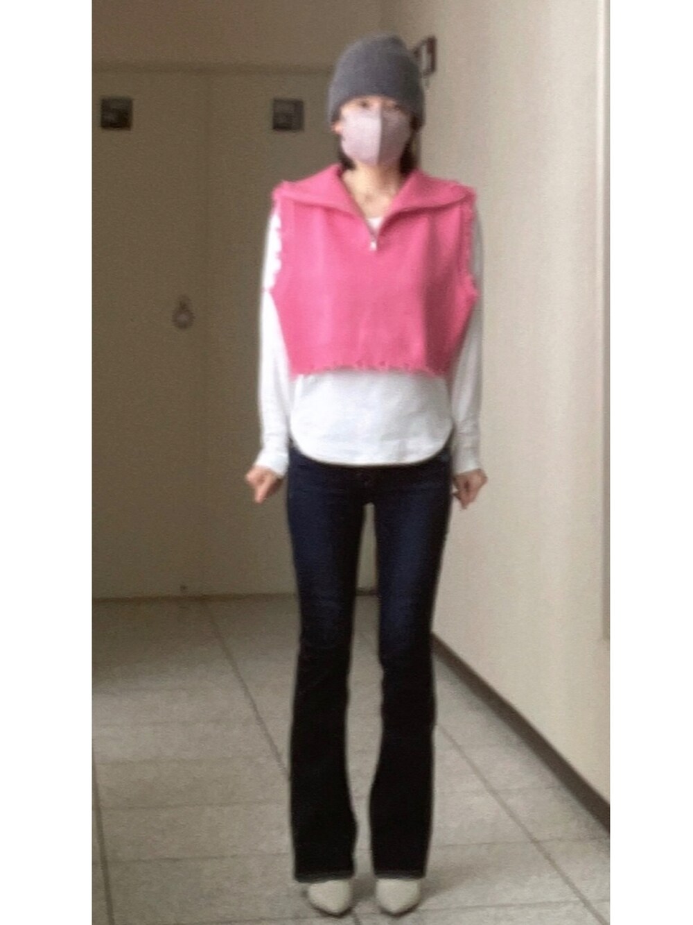 ホワイト系のTシャツ/カットソー、ピンク系のベスト、ブルー系のデニムパンツを着用したレディースの冬コーディネートの2枚目の写真