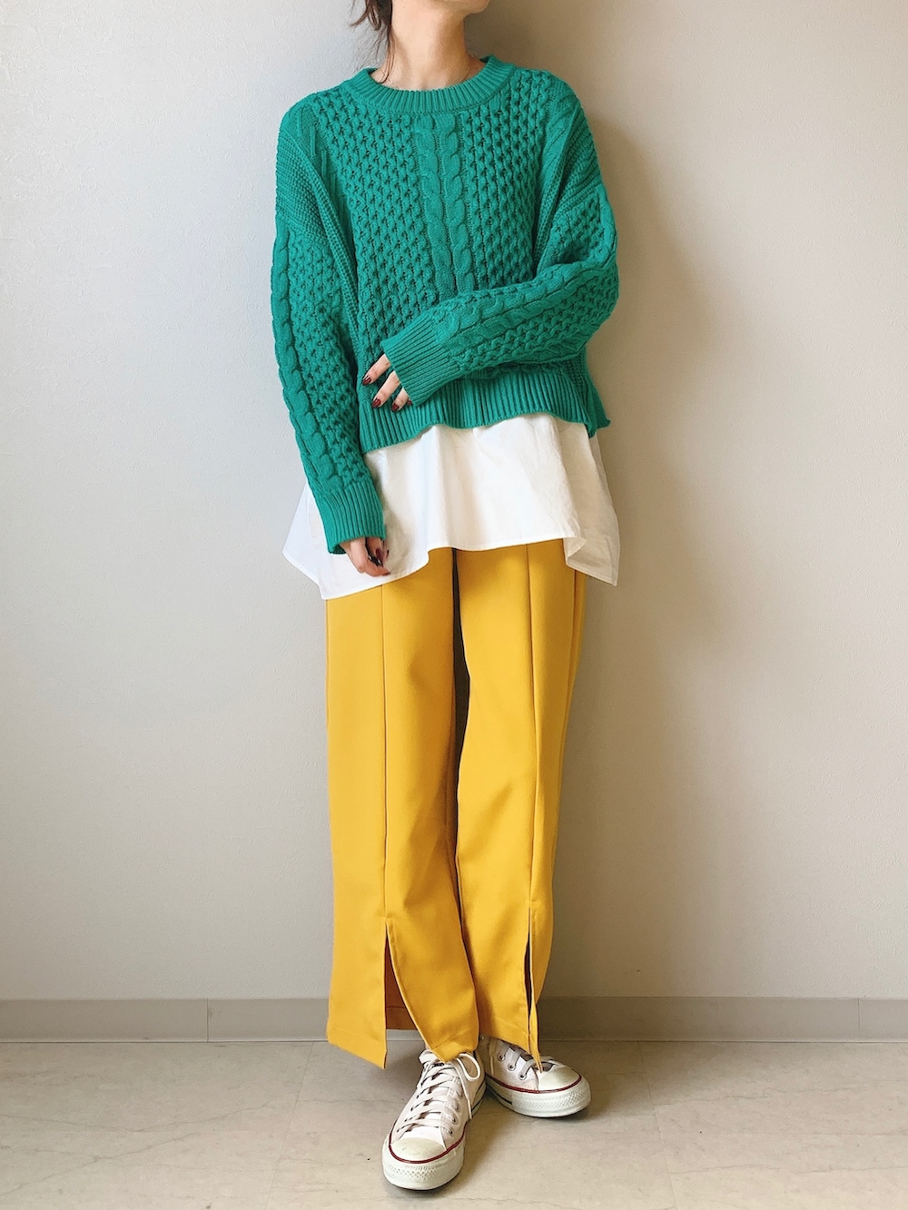 イエロー系のその他パンツ、グリーン系のニット/セーターを着用したレディースの冬コーディネートの3枚目の写真