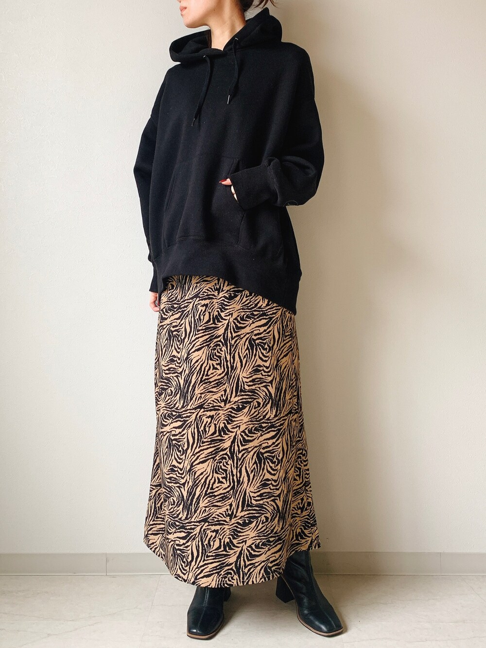 ブラック系のスウェット、ベージュ系のスカートを着用したレディースの冬コーディネートの2枚目の写真