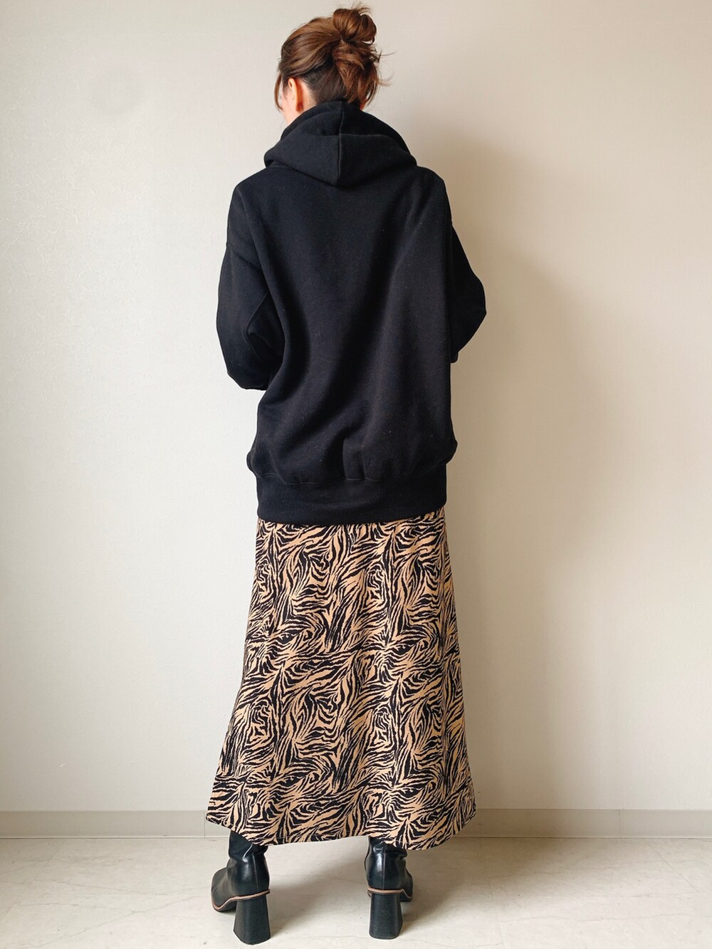 ブラック系のスウェット、ベージュ系のスカートを着用したレディースの冬コーディネートの3枚目の写真