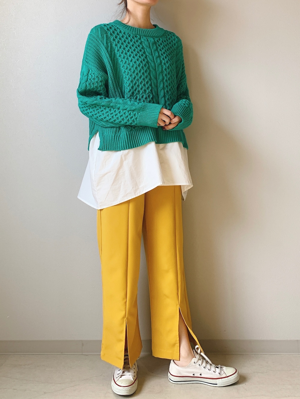 イエロー系のその他パンツ、グリーン系のニット/セーターを着用したレディースの冬コーディネートの2枚目の写真