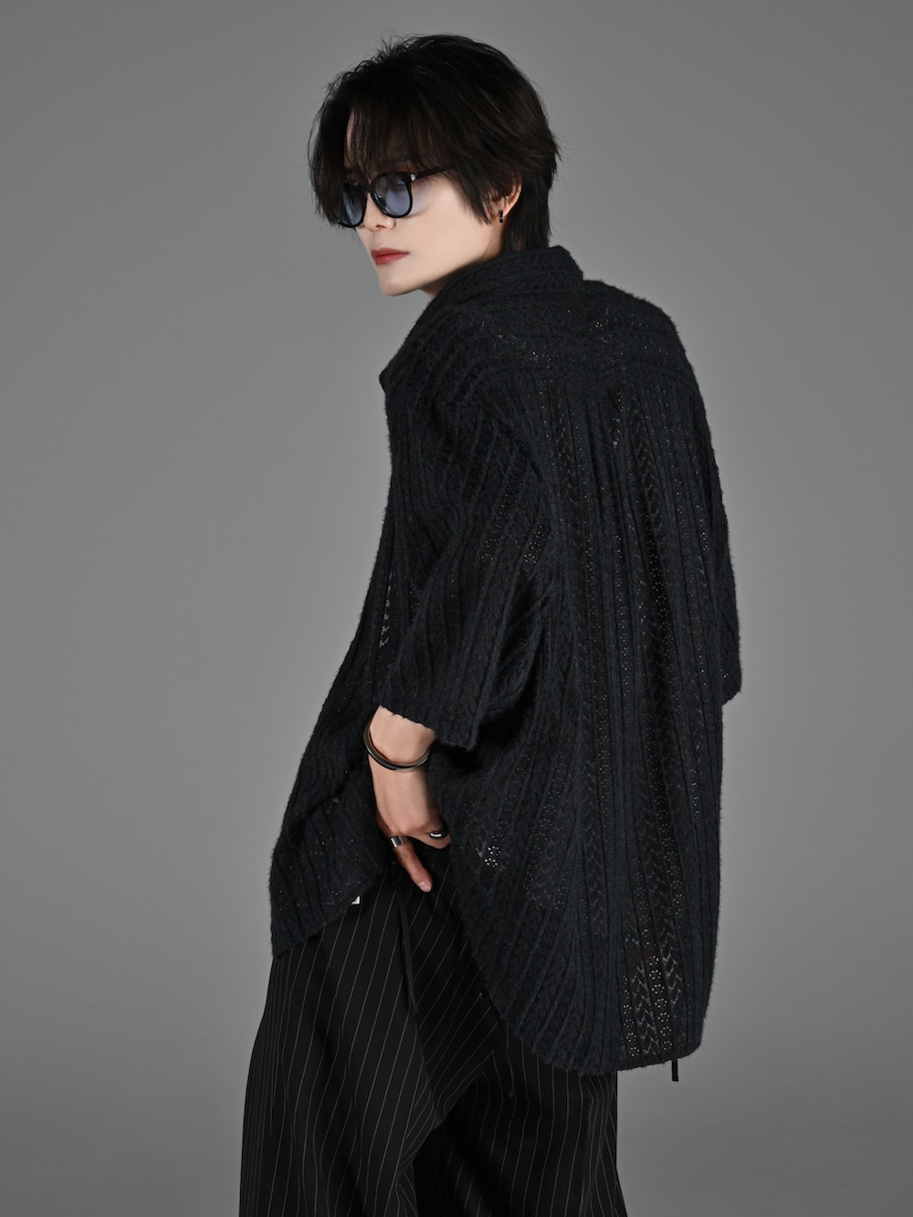 ブラック系のブーツ、グレー系のタンクトップ、ブラック系のスラックスを着用したメンズの春コーディネートの3枚目の写真