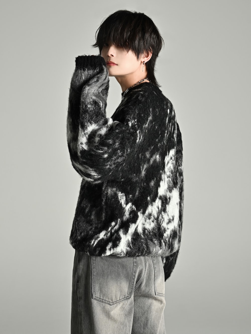 ブラック系のニット/セーター、ブラック系のショルダーバッグ、グレー系のデニムパンツを着用したメンズの秋コーディネートの5枚目の写真