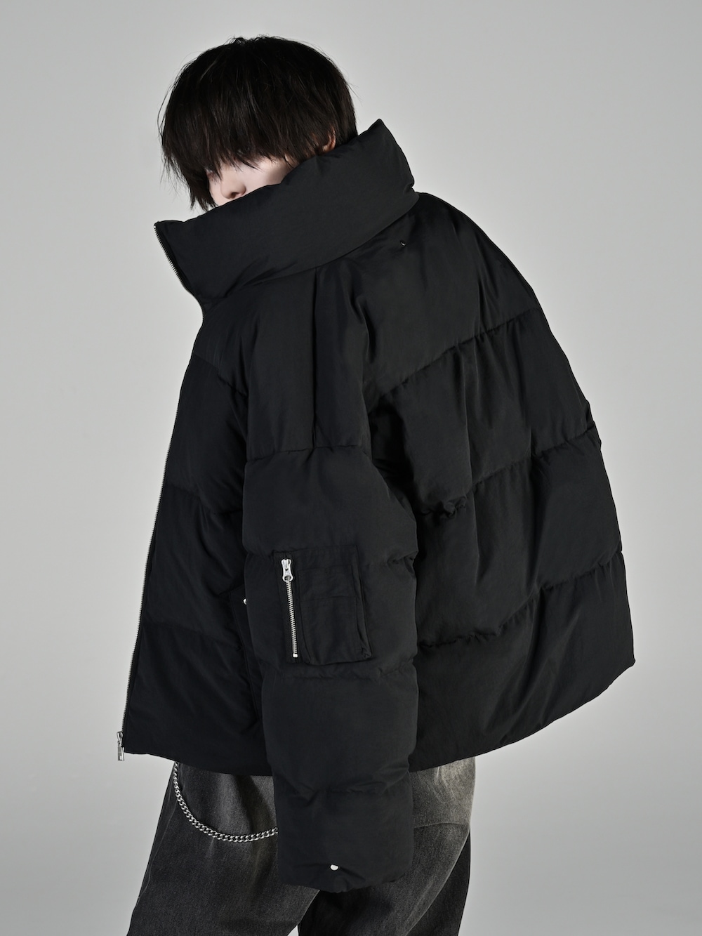 ブラック系のダウンジャケット/コート、ブラック系のTシャツ/カットソー、ブラック系のデニムパンツを着用したメンズの秋コーディネートの5枚目の写真