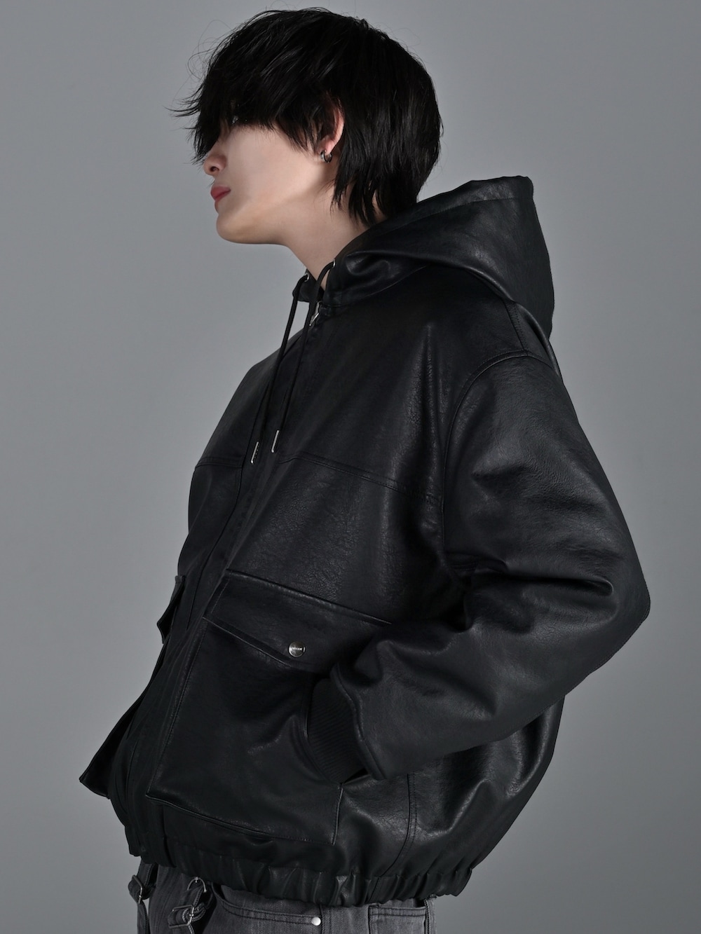 グレー系のスウェット、ブラック系のブルゾン、グレー系のデニムパンツを着用したメンズの春コーディネートの5枚目の写真