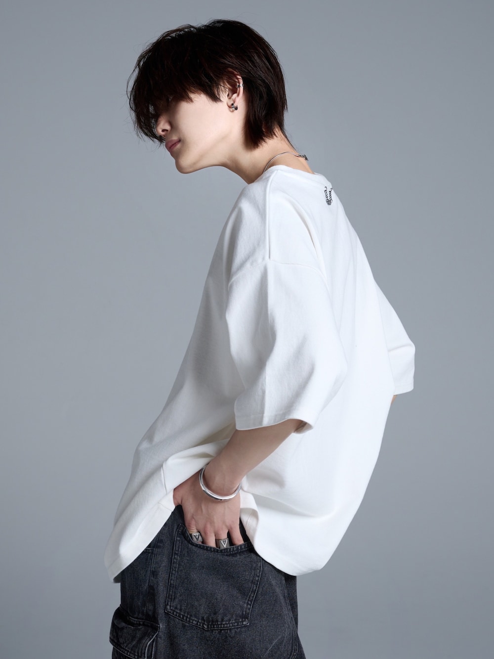 ブラック系のカーゴパンツ、ブラック系のスニーカー、ホワイト系のTシャツ/カットソーを着用したメンズの春コーディネートの4枚目の写真