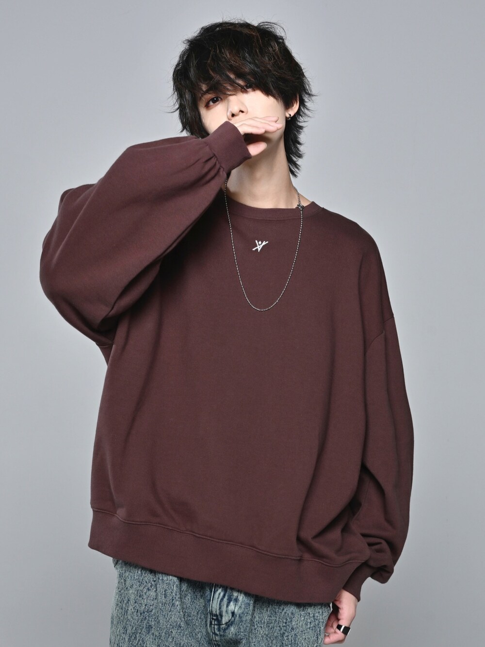 ホワイト系のスニーカー、ブラウン系のスウェット、ベージュ系のデニムパンツを着用したメンズの冬コーディネートの3枚目の写真