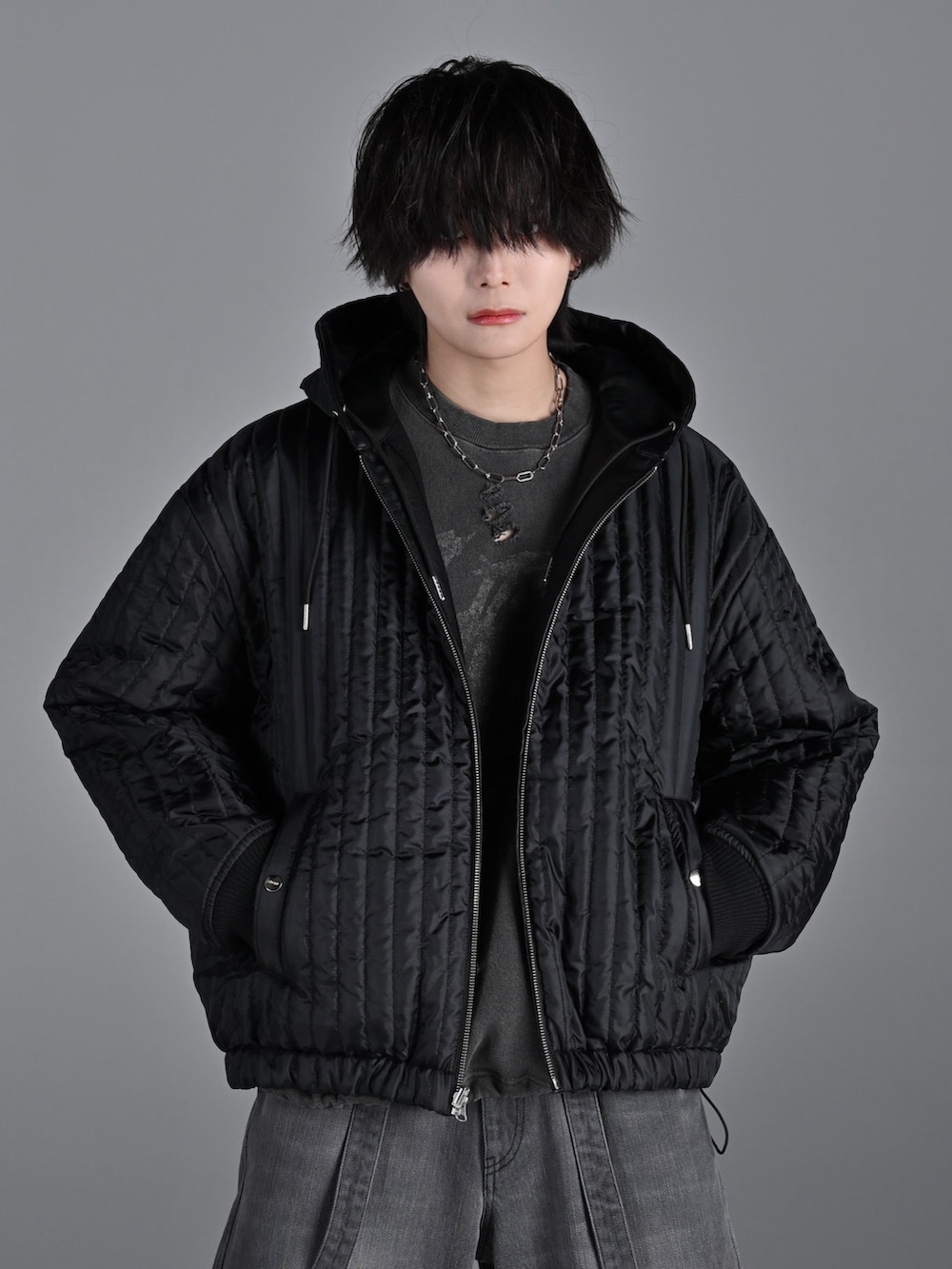 ブラック系のブルゾン、グレー系のスウェット、グレー系のデニムパンツを着用したメンズの冬コーディネートの2枚目の写真