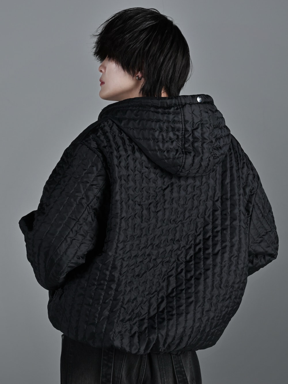 ブラック系のブルゾン、ブラック系のデニムパンツ、ホワイト系のスニーカーを着用したメンズの冬コーディネートの4枚目の写真