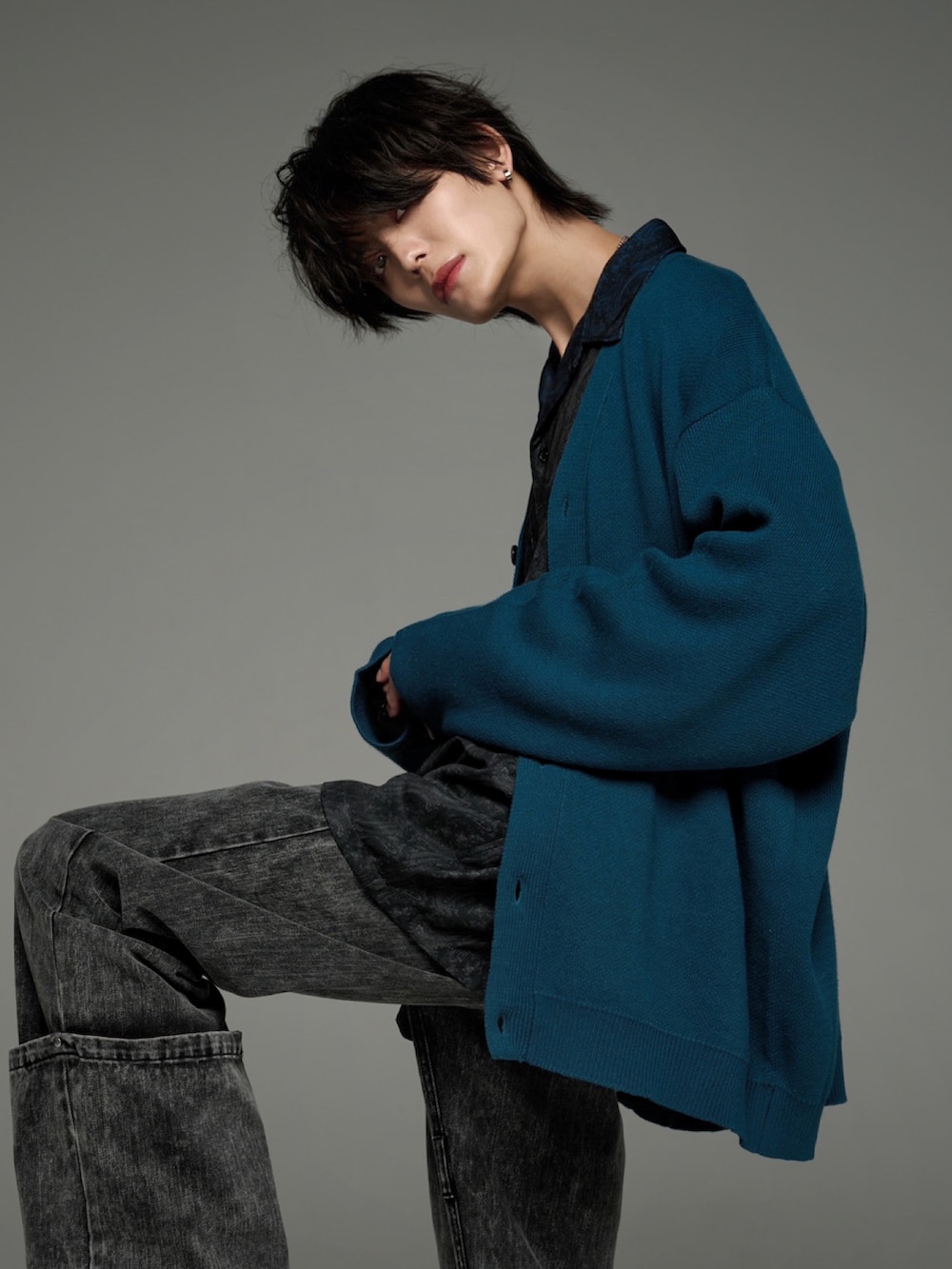 ブラック系のデニムパンツ、ブラック系のブーツ、グリーン系のカーディガン/ボレロを着用したメンズの秋コーディネートの5枚目の写真