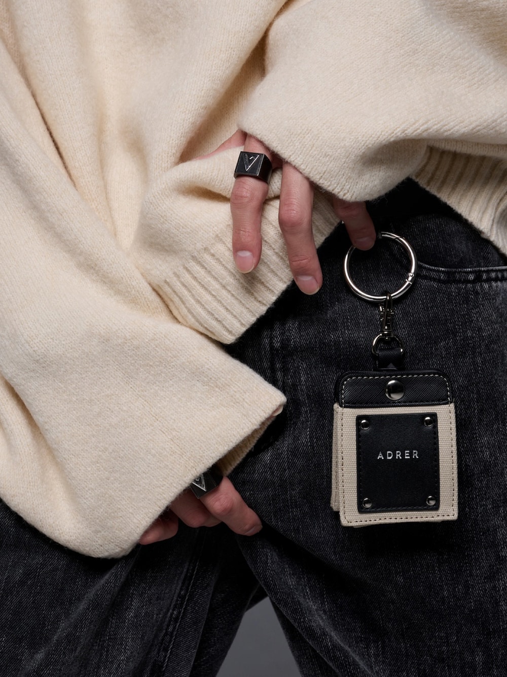 ブラック系のデニムパンツ、ブラック系のブーツ、ホワイト系のニット/セーターを着用したメンズの秋コーディネートの3枚目の写真