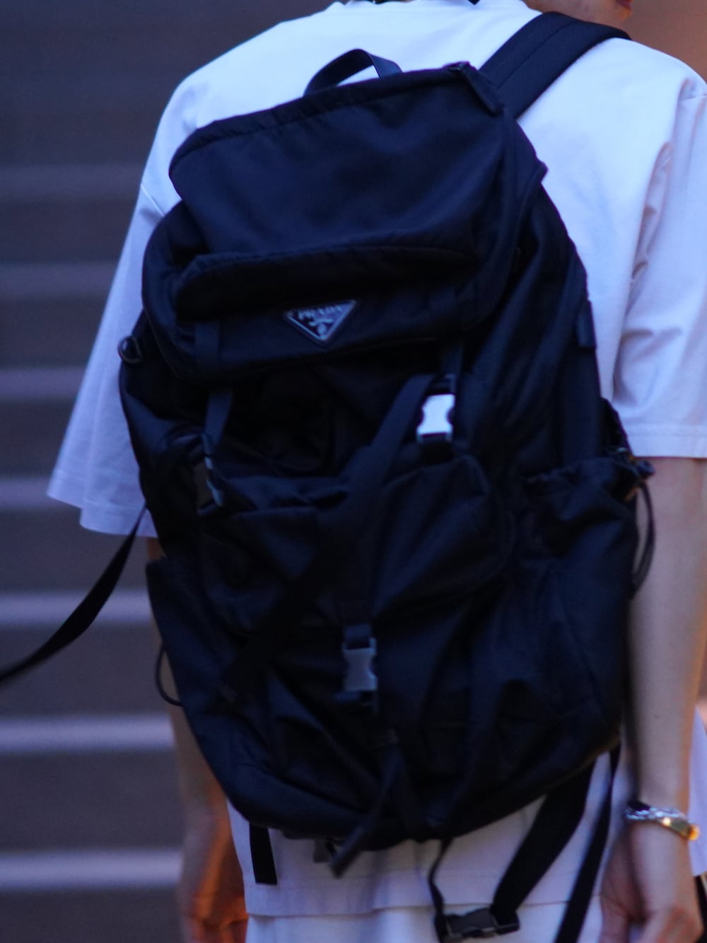 グレー系のTシャツ/カットソー、ブラック系のパンツ、ベージュ系のスニーカーを着用したメンズの春コーディネートの5枚目の写真