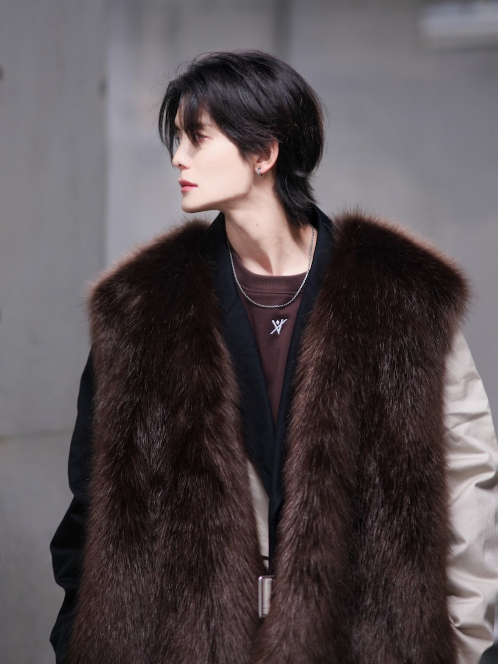 ベージュ系のトレンチコート、ブラック系のブーツ、ベージュ系のトートバッグを着用したメンズの冬コーディネートの5枚目の写真