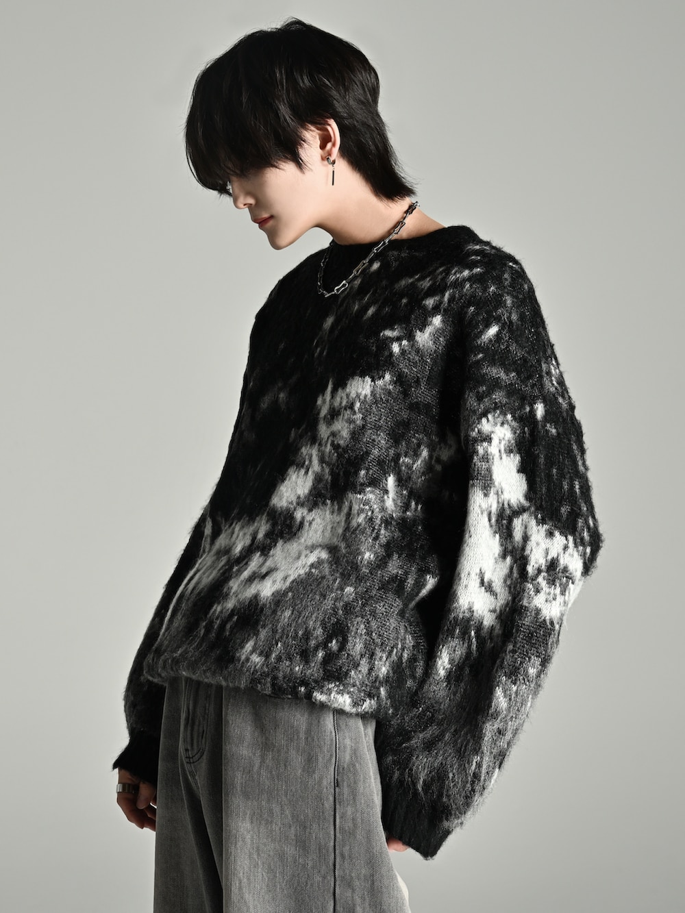 ブラック系のニット/セーター、ブラック系のショルダーバッグ、グレー系のデニムパンツを着用したメンズの秋コーディネートの4枚目の写真