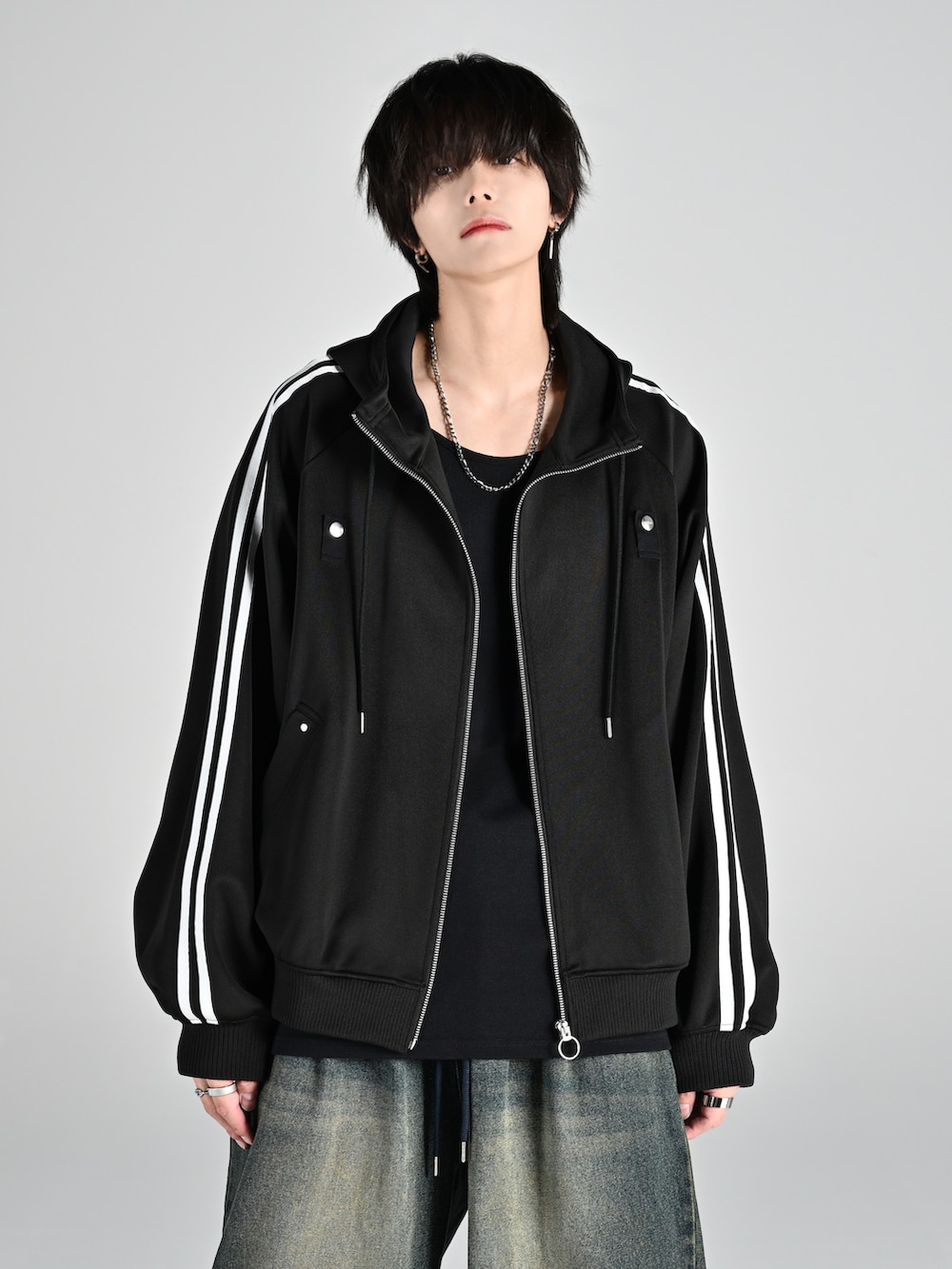 レッド系のタンクトップ、ブラック系のブルゾン、ホワイト系のスニーカーを着用したメンズの夏コーディネートの2枚目の写真