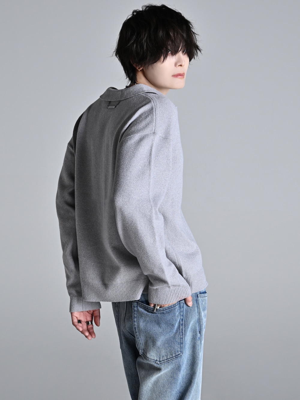 ブルー系のデニムパンツ、ブラック系のショルダーバッグ、ブラック系のブーツを着用したメンズの冬コーディネートの3枚目の写真