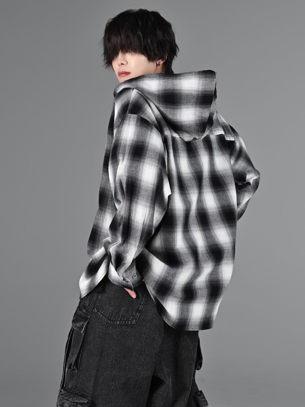 ブラック系のショルダーバッグ、ブラック系のカーゴパンツ、ホワイト系のスニーカーを着用したメンズの冬コーディネートの4枚目の写真