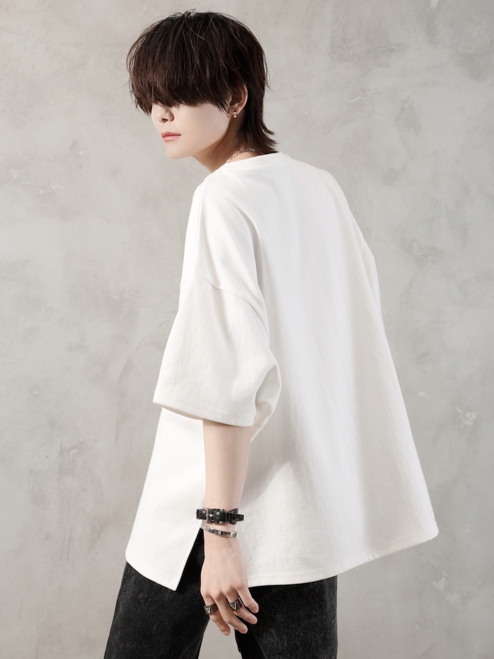 ブラック系のデニムパンツ、ホワイト系のTシャツ/カットソー、ブラック系のショルダーバッグを着用したメンズの春コーディネートの3枚目の写真