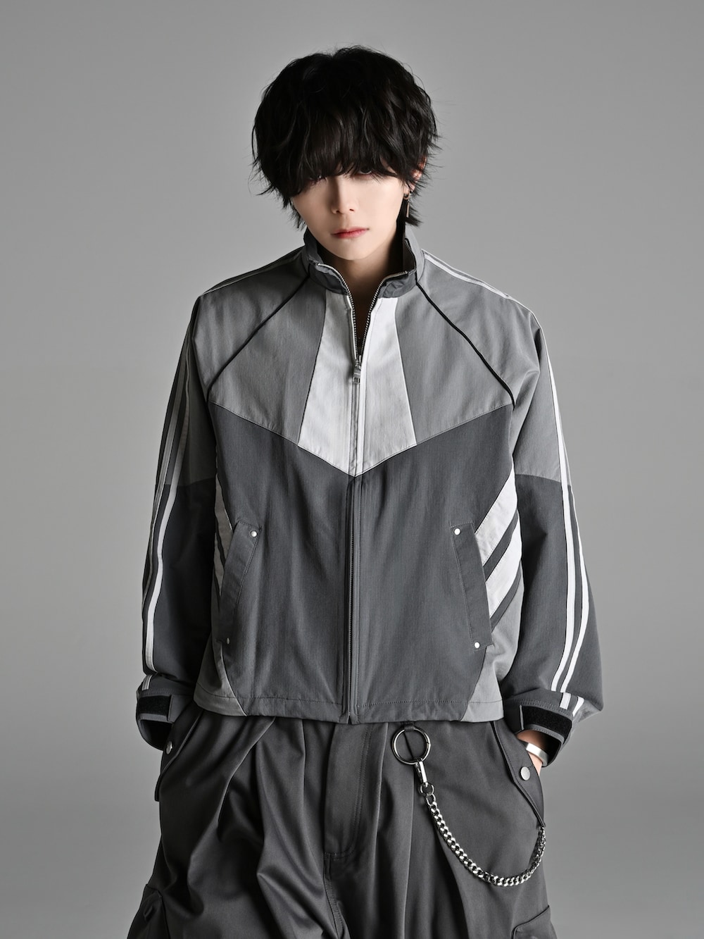 グレー系のカーゴパンツ、ブラック系のショルダーバッグ、ホワイト系のスニーカーを着用したメンズの冬コーディネートの2枚目の写真