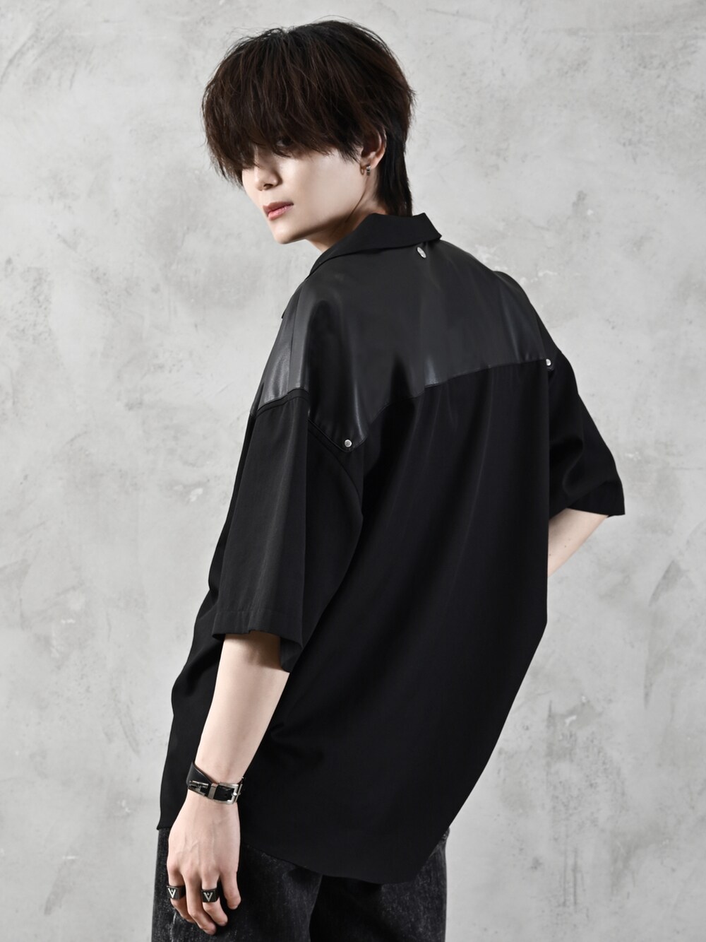 ブラック系のデニムパンツ、ブラック系のブーツ、ブラック系のショルダーバッグを着用したメンズの春コーディネートの4枚目の写真