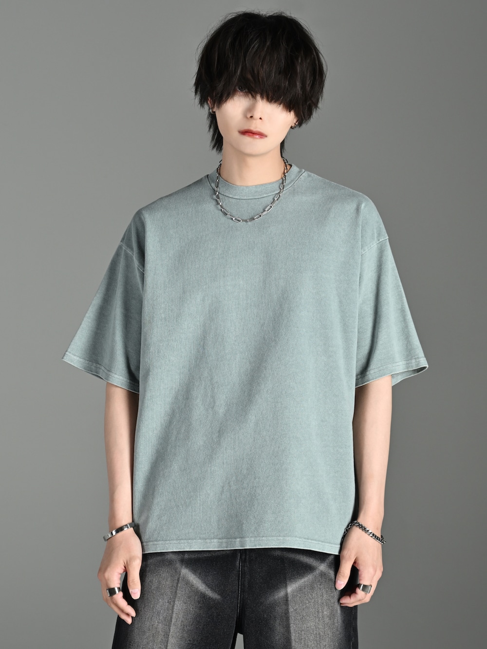 ブラック系のショルダーバッグ、グリーン系のTシャツ/カットソー、ブラック系のサンダルを着用したメンズの夏コーディネートの4枚目の写真