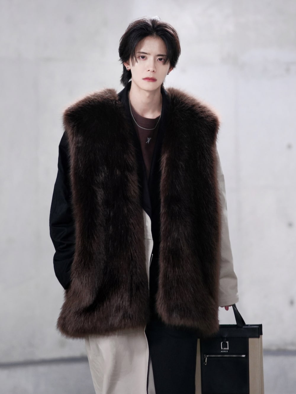 ベージュ系のトレンチコート、ブラック系のブーツ、ベージュ系のトートバッグを着用したメンズの冬コーディネートの3枚目の写真